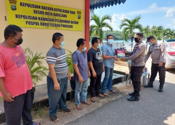 Polsek Kawasan Pelabuhan Batam Bagikan Bansos Kepada Masyarakat Sekitar Pelabuhan Roro Punggur