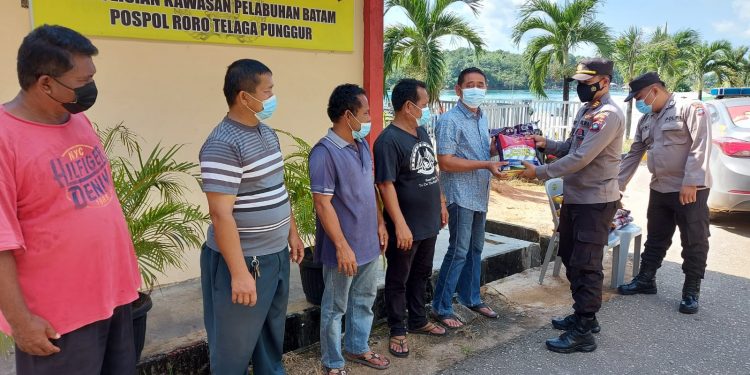 Polsek Kawasan Pelabuhan Batam Bagikan Bansos Kepada Masyarakat Sekitar Pelabuhan Roro Punggur