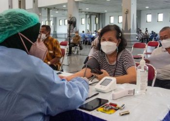 Petugas memeriksa kesehatan calon penerima vaksin booster COVID-19 di Jogja Expo Center, Bantul, DI Yogyakarta, Kamis (13/1/2022). ANTARA FOTO/Hendra Nurdiyansya