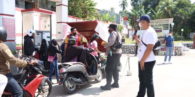 Kapolres Karimun Memberikan Minyak Pertalute Gratis Kepada Pengendara Bermotor yang Ingin Vaksin